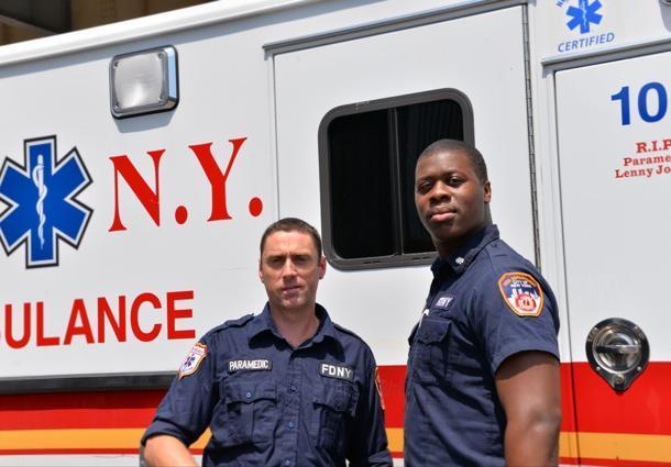 EMT Niall O’Shaughnessy, left, and his partner Moses Nelson stand by their emergency vehicle.